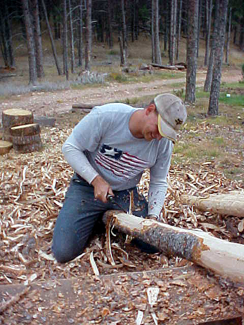 Josh is peeling a fresh-cut Ponderosa Pine with a drawknife.